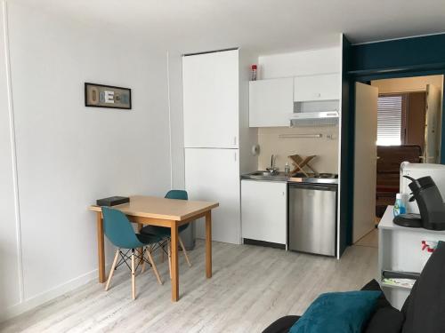 Ce petit appartement comprend une table et une cuisine. dans l'établissement ღ Le Désiré - Studio Proche Mer, Port et Centre, à La Rochelle