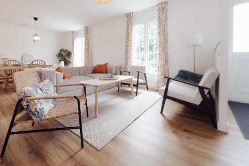 un salon avec un canapé, une table et des chaises dans l'établissement Grande maison & annexe, à deux pas de la Rochelle, à Nieul-sur-Mer