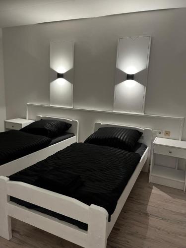 a bedroom with two beds and two lights on the wall at Pension Plesse-Blick Bovenden in Bovenden