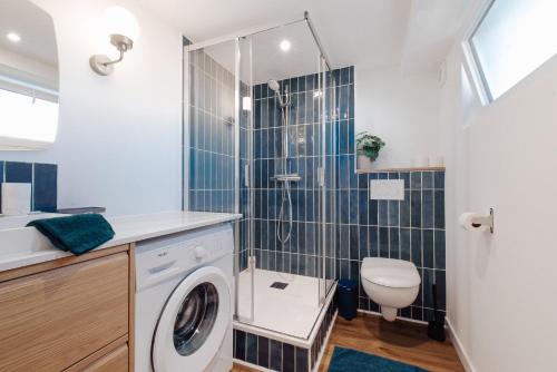 a bathroom with a washing machine and a toilet at Grande maison & annexe, à deux pas de la Rochelle in Nieul-sur-Mer