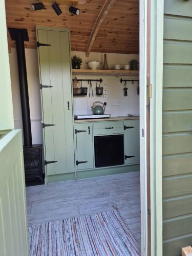 a kitchen with white cabinets and a stove at Clissmann Farm Shepherds Hut in Rathdrum