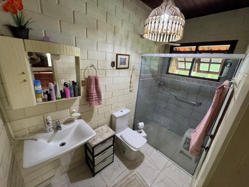 a bathroom with a sink and a shower and a toilet at Toca do Camarão in São Sebastião