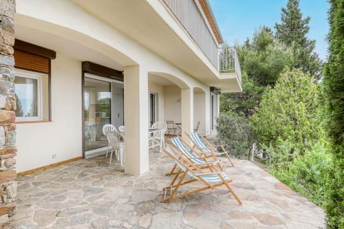un patio avec des chaises à bascule sur une maison dans l'établissement Bright apartment with terrace and sea view Le Lavandou, au Lavandou