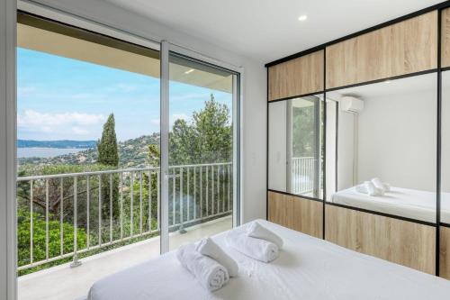 une chambre avec un lit et une grande fenêtre dans l'établissement Renovated 1-bedroom apartment with sea view and large balcony Aiguebelle, au Lavandou