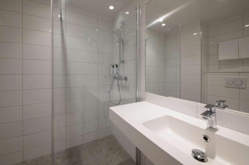 a white bathroom with a sink and a shower at Scandic Sunnfjord Hotel & Spa in Førde