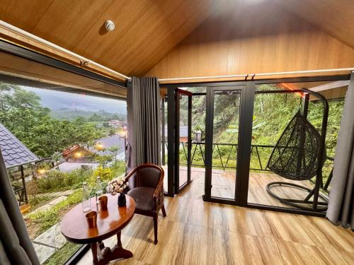 a room with a table and a large window at Đông Giang Sky Villa in A Sơ Ră Amo
