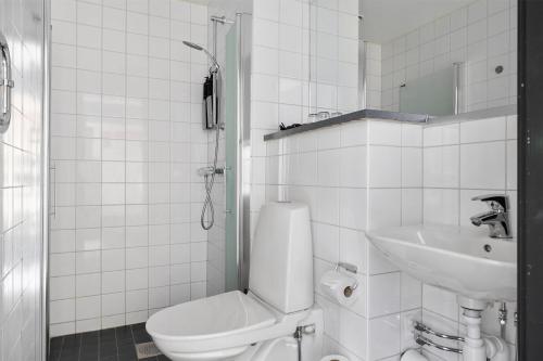 a white bathroom with a toilet and a sink at Best Western Hotel Norrkoping City in Norrköping