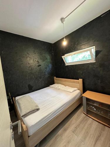 una piccola camera da letto con un letto e una finestra di River house Una a Kravlja