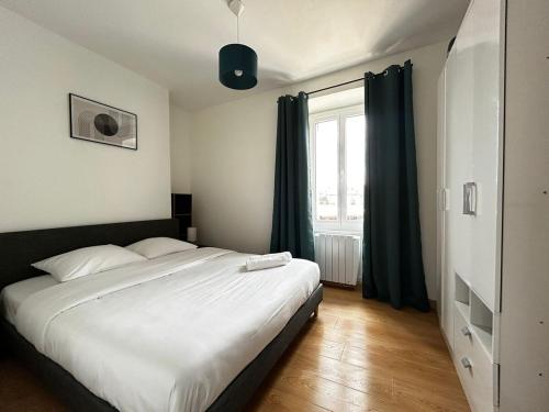 une chambre avec un grand lit blanc et une fenêtre dans l'établissement Le Quartier des Saveurs, proche des Halles Carnot, à Limoges