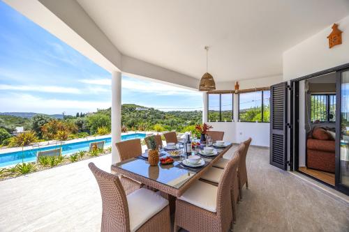 a dining room with a table and chairs and a pool at Private Oasis in Algarve with Pool & Fruit Garden in Loulé