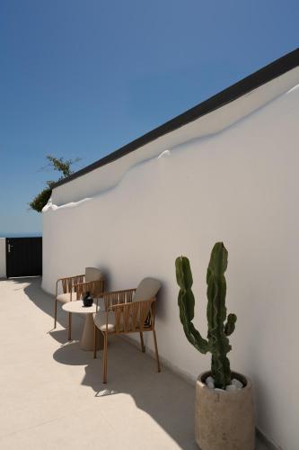 a patio with two chairs and a cactus at U & ME SUITES in Fira