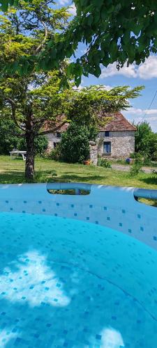 a blue swimming pool with a house in the background at Gîte 4 pers proche cure thermale, Futuroscope, calme et nature à La Roche Posay in La Roche-Posay