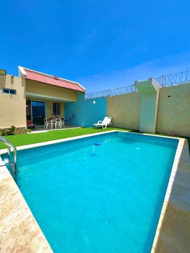 a swimming pool in front of a house at Beachfront Cabin with Private Pool in Puerto Colombia