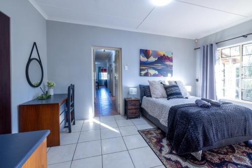 a bedroom with a bed and a dresser and a window at Pelican Palms Aston Jeffreys Bay in Jeffreys Bay