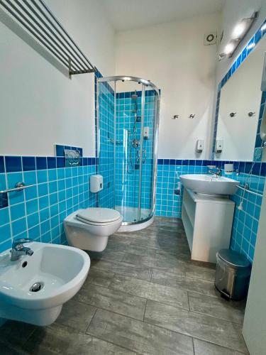 a blue tiled bathroom with a toilet and a sink at La Locanda di Piazza in Santa Teresa Gallura