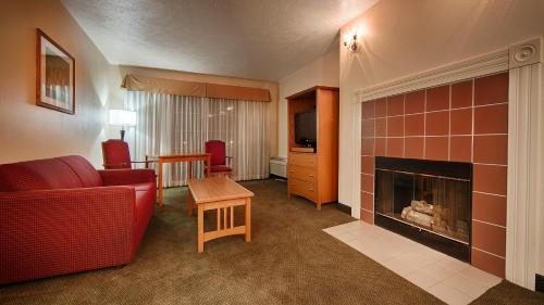 a living room with a red couch and a fireplace at Best Western John Jay Inn in Calexico