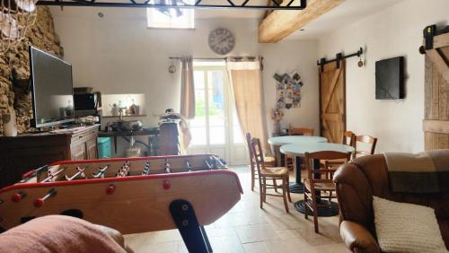 - un salon avec un billard et une salle à manger dans l'établissement Les naturelles, à Saint-Aubin-de-Locquenay