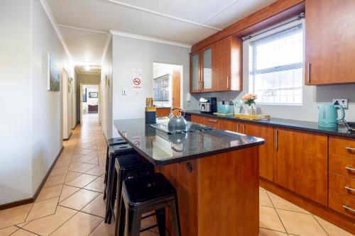 a kitchen with wooden cabinets and a counter top at Pelican Palms Aston Jeffreys Bay in Jeffreys Bay