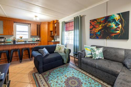 a living room with a couch and a kitchen at Pelican Palms Aston Jeffreys Bay in Jeffreys Bay