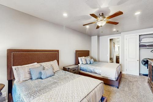 ein Schlafzimmer mit zwei Betten und einem Deckenventilator in der Unterkunft Zion’s Coral Ridge Escape in Washington
