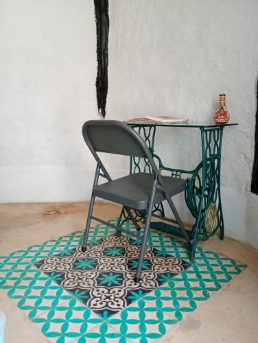 a chair sitting on a rug next to a table at Hotel y Museo Aldea Maya Toktli Orígenes - Casa Maya Toh - Alberca, Wifi Starlink, Tour Museo in Izamal