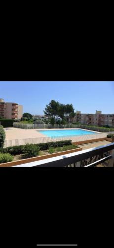 - une vue sur un bâtiment avec piscine dans l'établissement Appartement Favière-plage, Piscine-Terrain de tennis-Foot, à Bormes-les-Mimosas