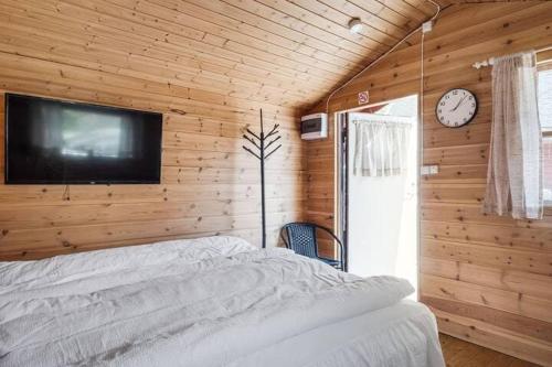 a bedroom with a bed and a tv on a wall at Trio of cottages near water in Maren