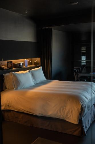 a bedroom with a large bed with white sheets at SO/ Vienna in Vienna
