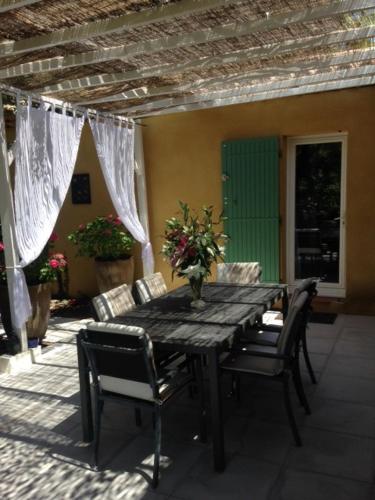 une table et des chaises en bois sur une terrasse dans l'établissement Villa provençale entre Aix en Provence et Luberon, à Rognes