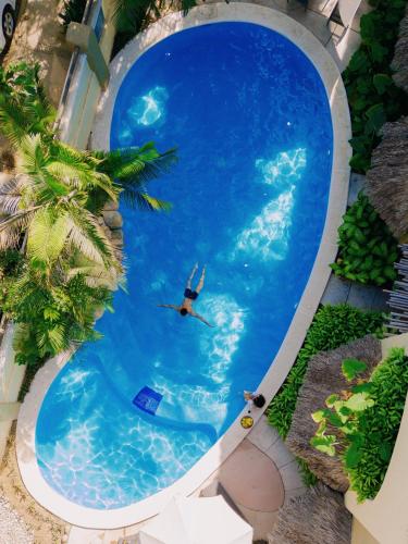 a man swimming in a large swimming pool at Casa Real Sayulita Hotel Boutique in Sayulita