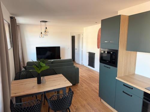 un salon avec un canapé et une table dans l'établissement Chez Eugène, appartement neuf, à Chaumont