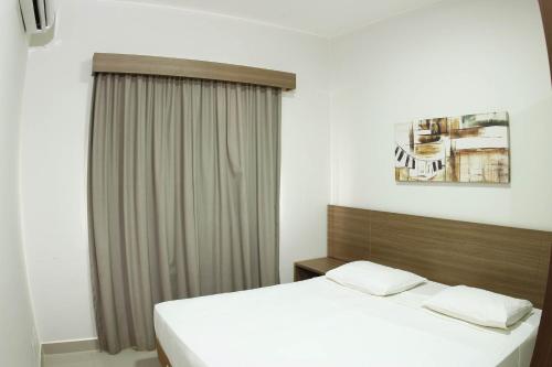 1 dormitorio con 2 camas y ventana en Hotel Marina - OFICIAL, en Caldas Novas