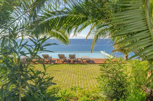a view of a beach with chairs and the ocean at Suite 5P Madeira Acqua Residence in Funchal
