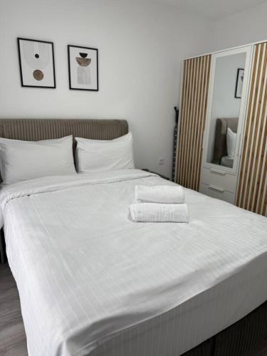 a large white bed with two towels on it at Serenity retreats VRT in Şelimbăr