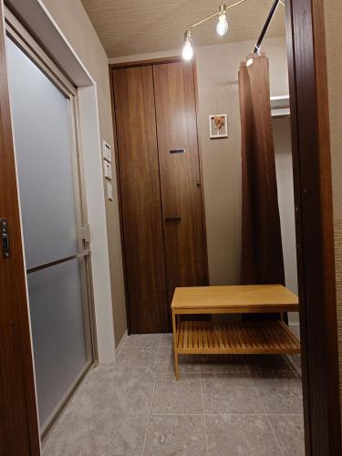a room with a wooden door and a wooden bench at Noctis豊田 ジャグジー肩湯付お風呂75型TV 最大12名宿泊可能 in Toyota