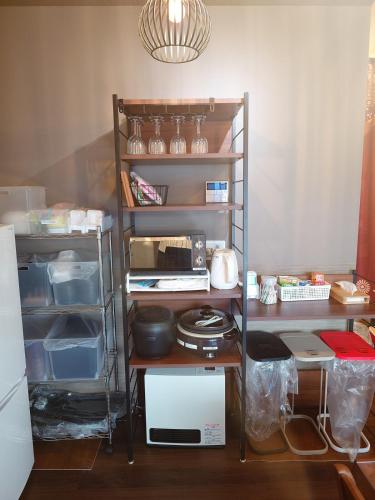 a kitchen with a refrigerator and shelves with food at Noctis豊田 ジャグジー肩湯付お風呂75型TV 最大12名宿泊可能 in Toyota