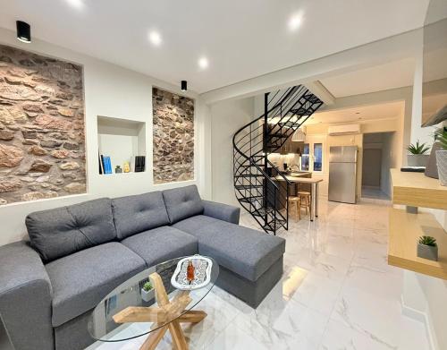 a living room with a blue couch and a staircase at Cozy Mytilene Downtown in Mytilini