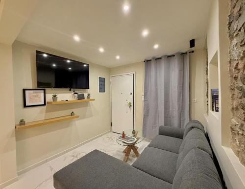 a living room with a couch and a tv at Cozy Mytilene Downtown in Mytilini