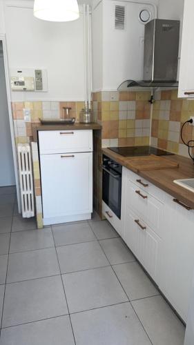 une cuisine avec des placards blancs et un appareil blanc dans l'établissement Appartement de 3 chambres pour 6 personnes, à Toulon