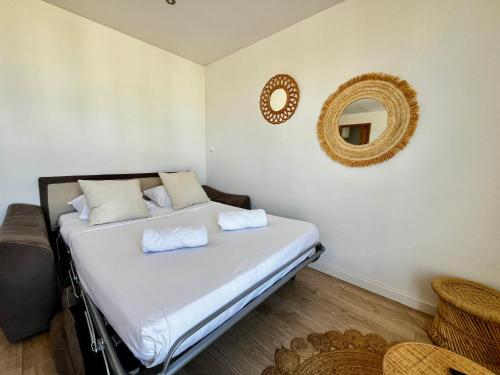 une chambre avec un lit avec un miroir au mur dans l'établissement Charmant studio bord de mer! Clim, à Palavas-les-Flots