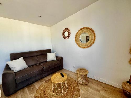 un salon avec un canapé marron et une table dans l'établissement Charmant studio bord de mer! Clim, à Palavas-les-Flots