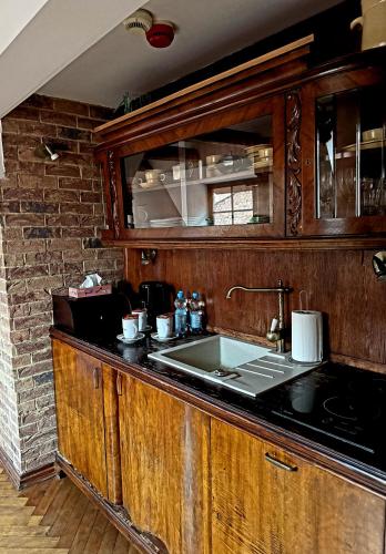 a kitchen with wooden cabinets and a sink at Apartamenty Molus na Rynku Staromiejskim in Toruń