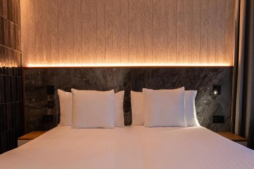 a bed with white pillows in a room at Silken Saaj Maar - Adults Only in Puerto de la Cruz