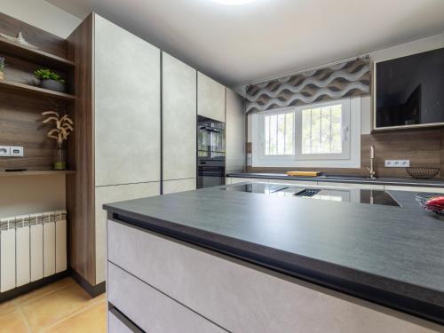 a large kitchen with a large black counter top at Holiday Home Villa Luz del Sol by Interhome in L'Ametlla de Mar