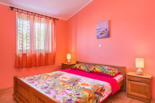 a bedroom with a bed with orange walls and a window at Apartments Villa Orange in Medulin
