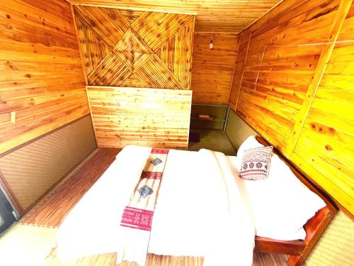 una habitación con dos camas en una cabaña de madera en Homestay Hồ Đá A Căng Tả Phìn, en Sa Pa