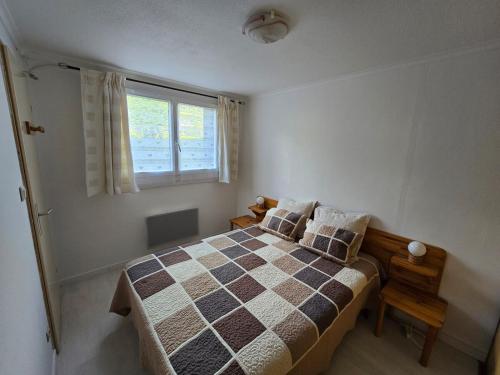 une chambre avec un lit et une fenêtre dans l'établissement Les Bartavelles, à Allemont