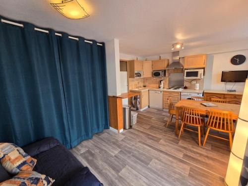 un salon avec un canapé et une table et une cuisine dans l'établissement Les Bartavelles, à Allemont