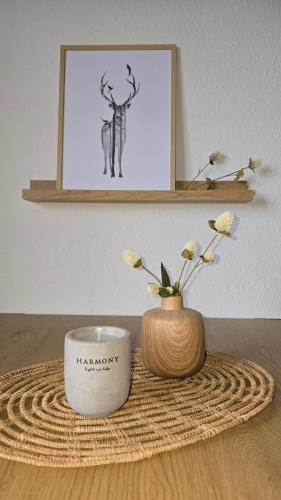 a table with a candle and a vase with flowers at Waldliebe in Bad Sachsa
