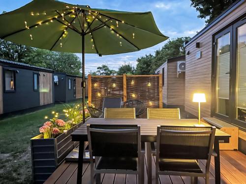 a patio with a table with a green umbrella at Holiday Home Tiny Haus Tiny Moments by Interhome in Wemding